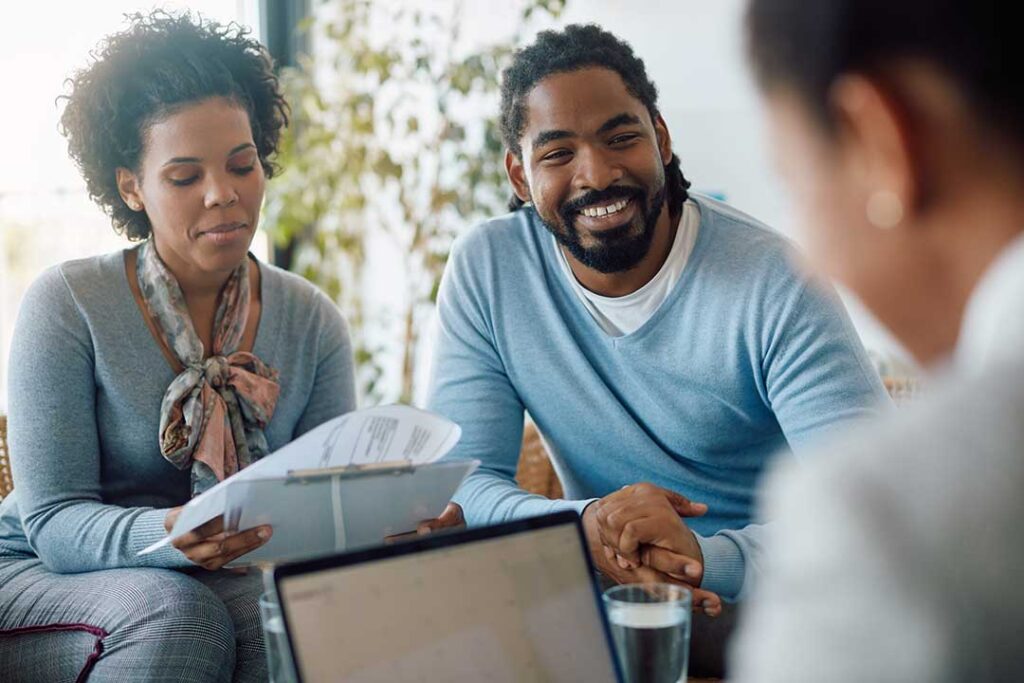A family reviewing insurance documents together in a comfortably furnished living room.